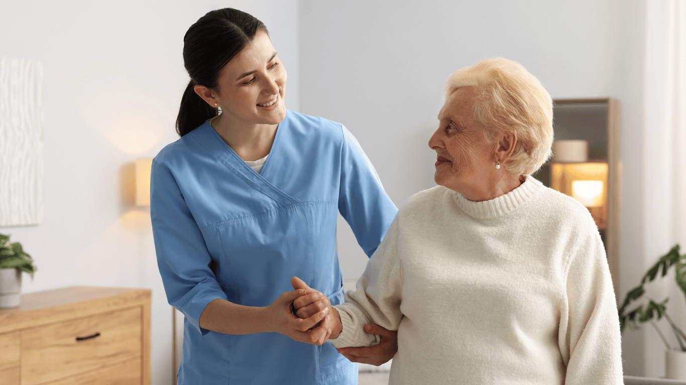 A caregiver assisting a walking senior with dementia in home care.
